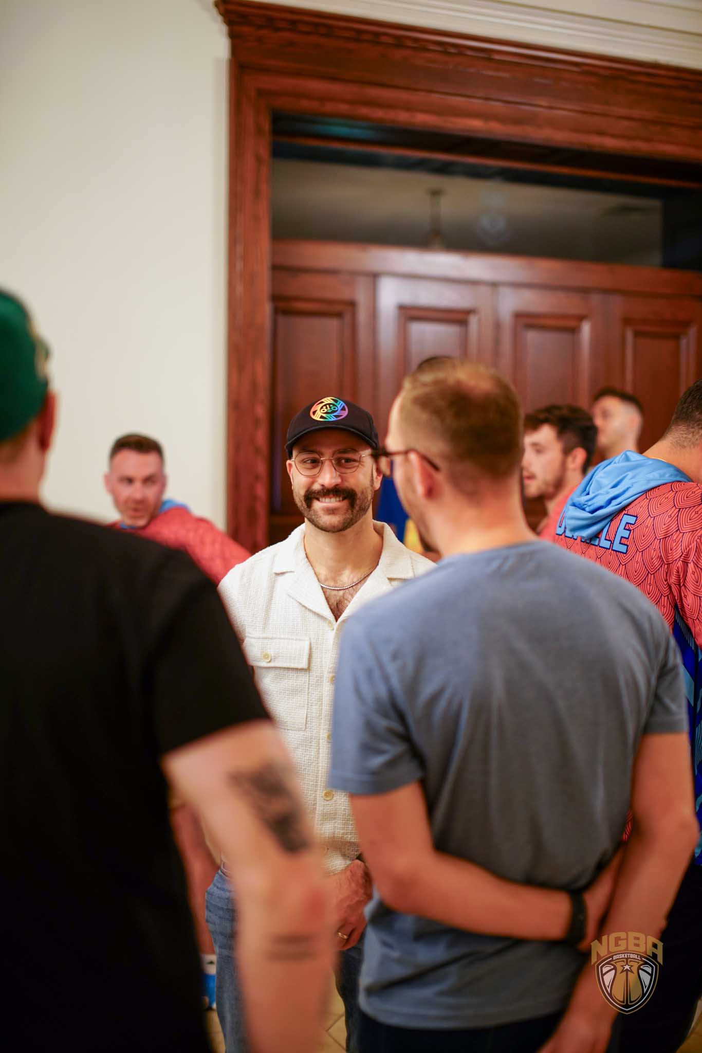 A man smiles while talking to friends