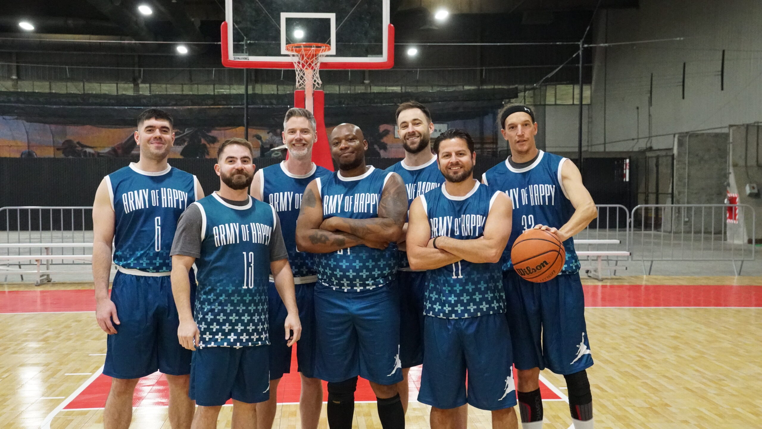 7 Men wearing basketball jerseys pose for picture