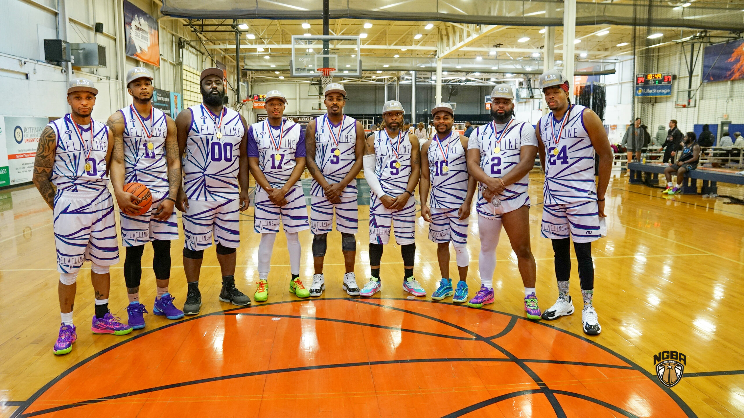 9 Men wearing basketball jerseys and championship hats pose for picture