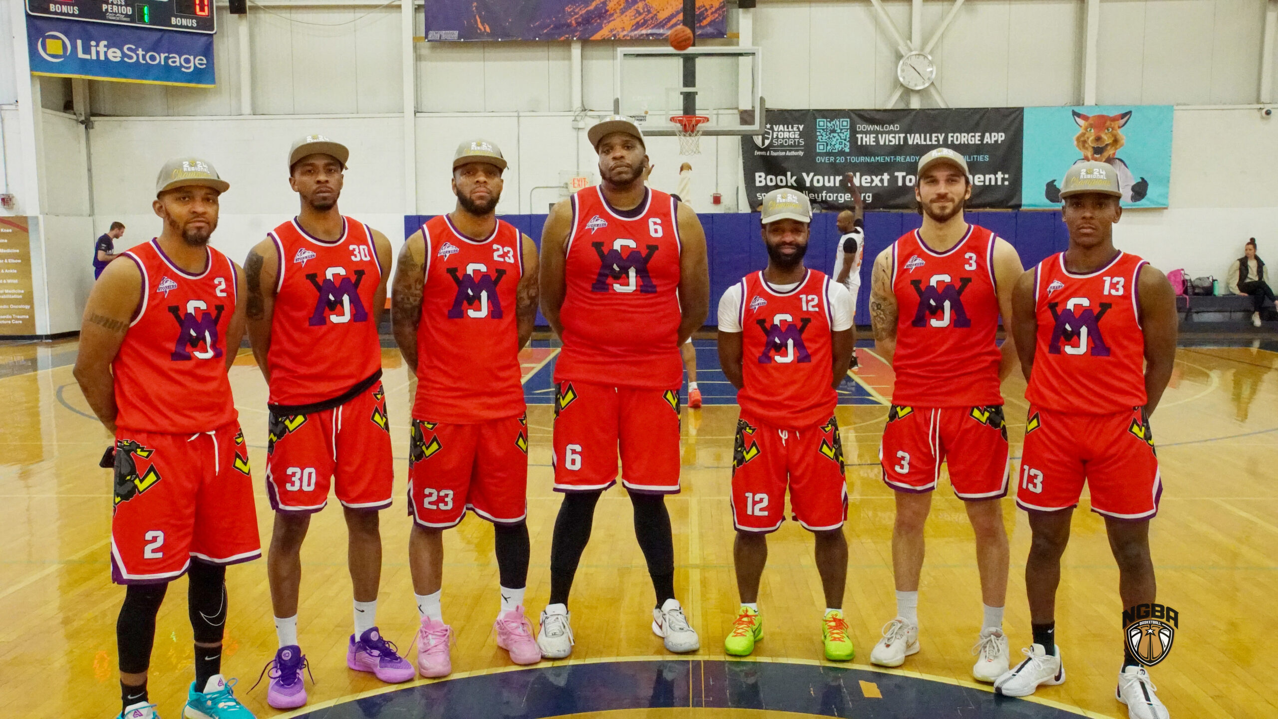 7 Men wearing basketball jerseys and championship hats pose for picture