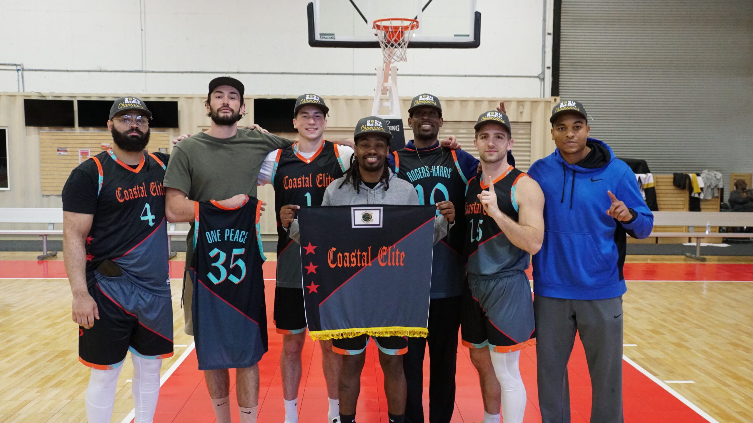 7 Men wearing basketball jerseys and championship hats pose for picture